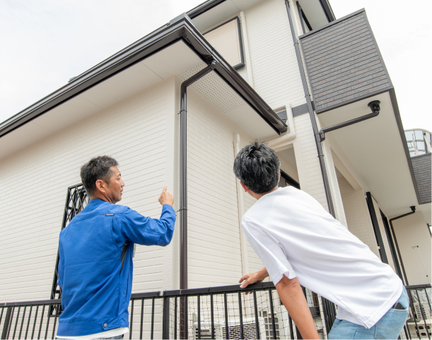 お客様と一緒に外壁を確認している