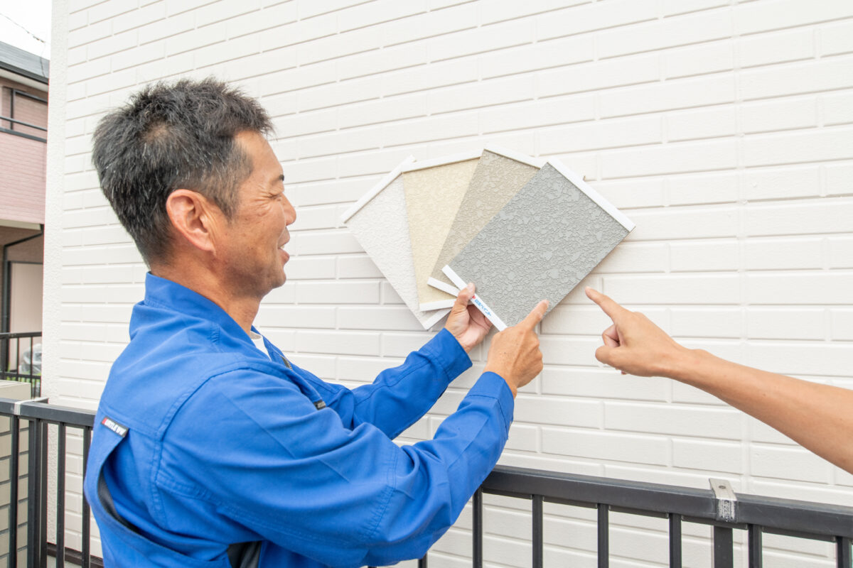 外壁にサンプルを当てて色を選んでいる
